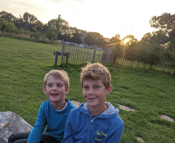 The boys sat on a bench by the campfire at Camp Wowo